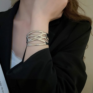 Silver wide hollow woven bangle worn with a black blazer for a minimalist fashion look