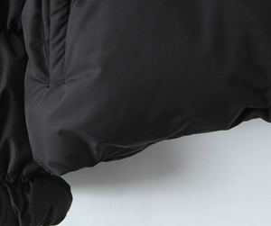 Detailed macro view of black puffer jacket stitching and high-quality fabric texture