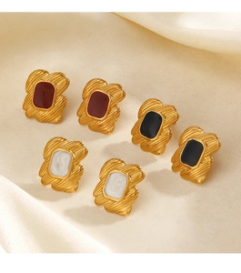Detailed close-up of retro geometric gold-plated earrings on soft beige silk