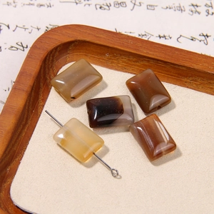 Macro detail of rectangular agate beads in brown and yellow on a wooden tray