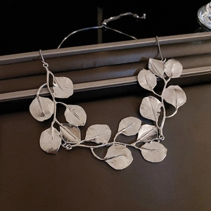 Detail of silver leaf design bracelet featuring a polished metallic finish and adjustable chain