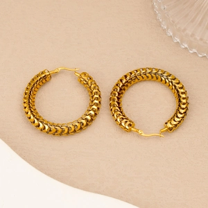 Macro shot of 18K gold plated hoop earrings with textured woven chain pattern design