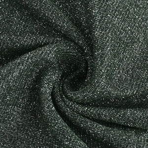 Detailed macro view of dark green sequined fabric texture with metallic shimmer effect