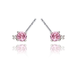 Detail view of round pink zircon studs with silver prong setting and white side stone