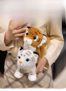 Detail of plush tiger toys in yellow and white featuring metal toy tags and soft fur texture
