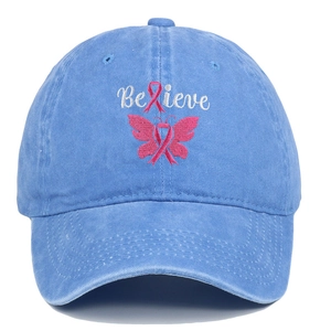 Close-up of pink ribbon butterfly embroidery and Believe text on sky blue denim cap