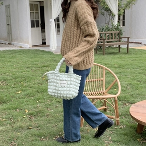 Close-up of mint green bubble puffer canvas tote with quilted texture and brand label