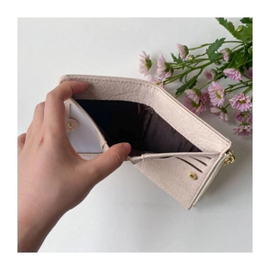 Detail of light pink pebble leather wallet with card slots and a secure zipper pocket