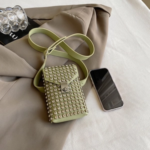 Chic light green rhinestone crossbody bag on a beige blazer with adjustable strap