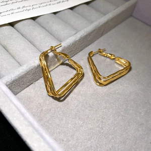 Detail of 18k gold plated geometric earrings in a jewelry tray for women