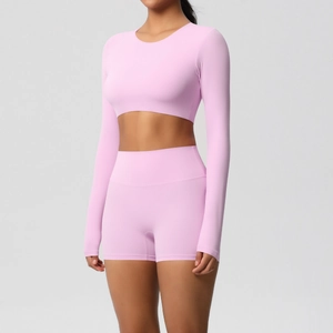 Close-up of pink long-sleeved yoga top and high-waisted gym shorts on a model