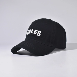 Close-up of TALES towel embroidery and fine stitching on a black cotton baseball cap