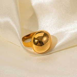 Vista macro di un anello a cupola in oro 18 carati su elegante sfondo in tessuto di seta bianca