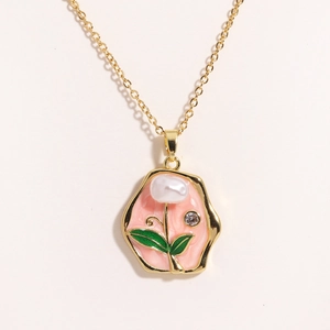 Detailed shot of flower pendant with pink enamel, natural pearl and green leaf accents
