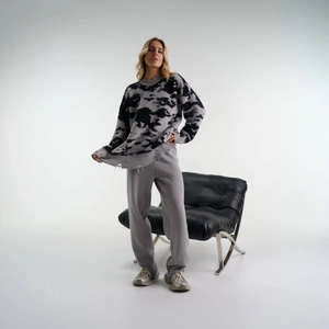 Detailansicht des distressed Saums und Wolkenmusters am Oversize-Strickpullover