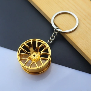 Detailed macro view of the golden metal alloy car wheel hub keychain with a polished finish