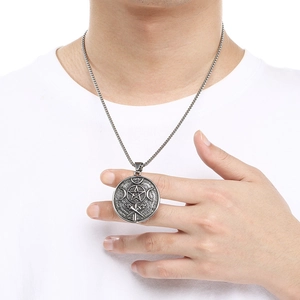 Close-up of vintage stainless steel pentagram and moon pendant necklace on a male model
