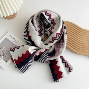 Detail view of colorful zigzag knit scarf with thick wool texture and wash label