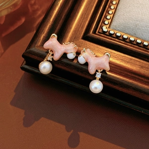 Detailed view of pink horse earrings with 18K gold plating, pearls, and crystals