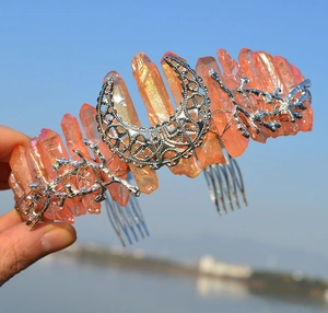 Macro view of orange crystal crown featuring a silver metal moon and branch accents