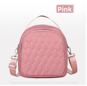 Detailed front view of pink quilted nylon mini bag with adjustable straps and zippers