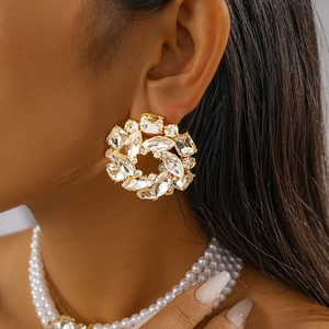Macro shot of large floral crystal stud earrings with gold setting on model side view