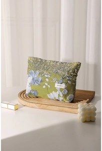 Close-up of floral jacquard makeup bag in olive green with H&R BAG woven label