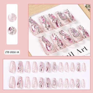 Macro detail of pink glitter press-on nails with luxury rhinestones and pearls