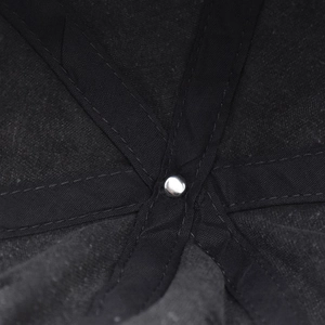 Macro detail of the interior crown stitching and silver metal rivet on the black cotton cap