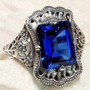Bague vintage ajourée en argent avec zircon bleu royal taille émeraude et gravure florale