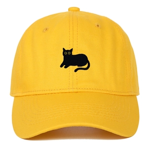 Close-up of a yellow cotton baseball cap featuring a black cat embroidery and curved brim