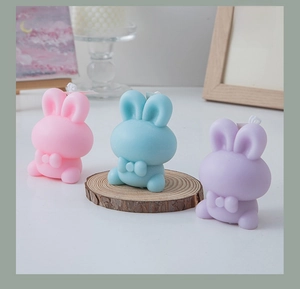 Detailed view of pastel bunny scented candles in pink, blue, and purple with bow details