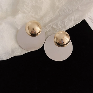 Detailed macro view of minimalist two-tone silver and gold geometric round stud earrings