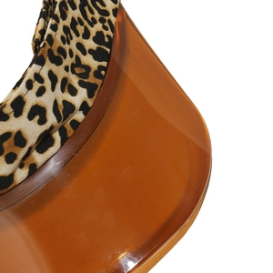 Detail of leopard print fabric headband and orange translucent plastic sun visor brim