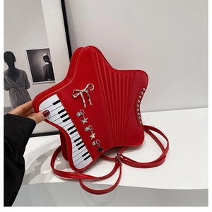 Detail of red star-shaped bag featuring piano key patterns and silver bow ornament