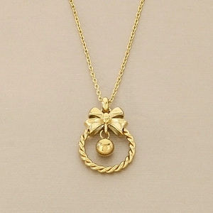 Détail du pendentif nœud doré avec anneau torsadé et élégante breloque perle