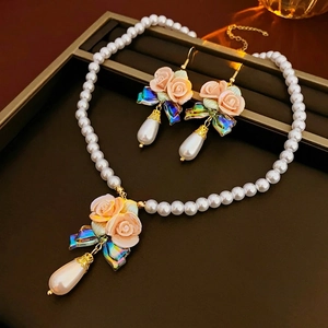 French ceramic floral necklace with iridescent bow and teardrop pearl on leather box
