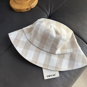 Detailed top view of a breathable linen checkered bucket hat on black leather background
