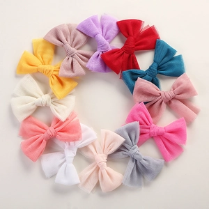 Overhead view of colorful mesh bow hair clips arranged in a circle on white background