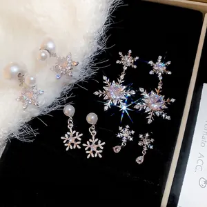 Elegante silberne Schneeflocken-Ohrringe mit Perlen und Zirkonia auf schwarzem Samt