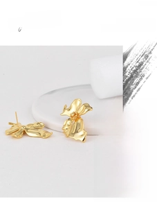 Detail of high quality gold plated flower earrings with 3D petals and textured centers