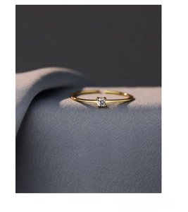 Macro shot of minimalist S925 sterling silver gold ring with round white zircon stone