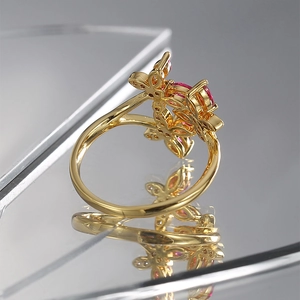 Detailed close-up of gold butterfly ring with inlaid pink marquise zircon gemstones