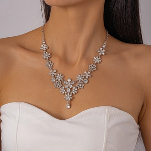 Detailed view of silver flower necklace with crystals on model for elegant wedding style