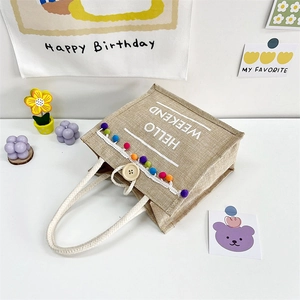 Jute tote bag with Hello Weekend print, colorful tassel charms, and wooden button closure