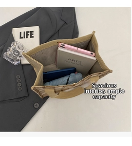 Top view of spacious interior of a beige checkered canvas tote bag with various items