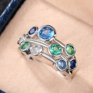 Silver multi-layer ring with blue and green round gemstones in a velvet jewelry box