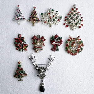 Detaillierte Flachbildaufnahme von zehn kristallbesetzten Weihnachtsbroschen auf Weiß