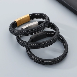 Gros plan de bracelets en cuir tressé pour hommes avec fermoir magnétique et surpiqûres