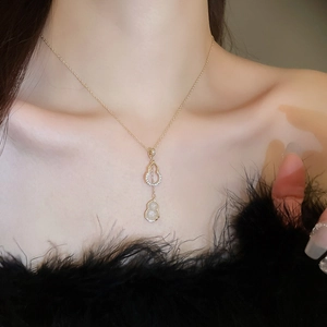 Détail du collier plaqué or avec pendentif double gourde serti de zircones et jade